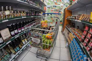 Carrinho de mercado com compras entre duas prateleiras de mercado